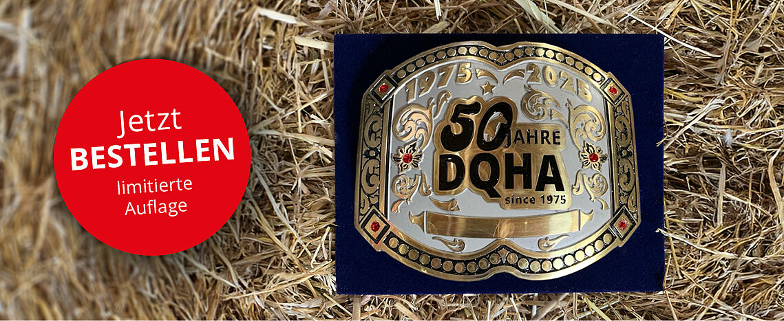 Goldfarbene Gürtelschnalle mit der Aufschrift ‚50 Jahre DQHA since 1975‘ und den Jahreszahlen ‚1975 – 2025‘ liegt auf Stroh; links ein roter Kreis mit dem Text ‚Jetzt BESTELLEN – limitierte Auflage‘.
