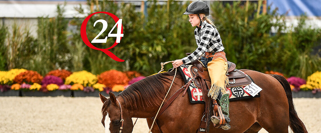Kind reitet ein braunes Pferd im Westernsattel in einer Reithalle, trägt Helm und Westernkleidung; im Hintergrund farbige Blumen, links das DQHA-24-Symbol.